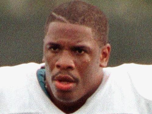 (FILES) This file photo taken on December 2, 1997 shows Miami Dolphins' new running back Lawrence Phillips (L) walking off the practice field with coach Kippy Brown after his first day of workouts with the team in Davie, Florida. Troubled former NFL running back Lawrence Phillips has been found dead in a California prison where he was awaiting trial for killing a cellmate, authorities said January 13. Phillips, who had spells with the St Louis Rams, Miami Dolphins and San Francisco 49ers before ending his professional career in Canada in 2003, was believed to have committed suicide, a statement from the California Department of Corrections said. The 40-year-old had been kept in solitary confinement at Kern Valley State Prison after being accused of killing a cellmate in 2013. / AFP / RHONA WISE