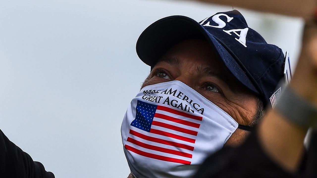 A supporter of US President Donald Trump wears a Trump mask as he participates in a "Freedom Rally". Picture: Chandon Khanna/AFP