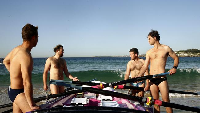 L to R: James Samuels, Sam Horsley, Louis Hugh-Jones and Rob Wells putting a Surf boat in the water at North Bondi. They will from the Canary Islands to Antigua and Baruda, raising money for a great cause. Picture: John Appleyard