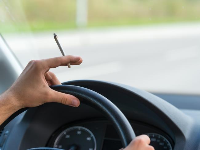 Close-up of a men driving and smoking joint