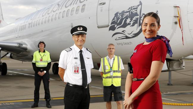 Virgin staff Phil Vlieg, Captain Anthony Saville, Peter Armstrong and Alahna Wilkinson posing in front of Long Beach, 737-800 at Brisbane. Picture: AAP