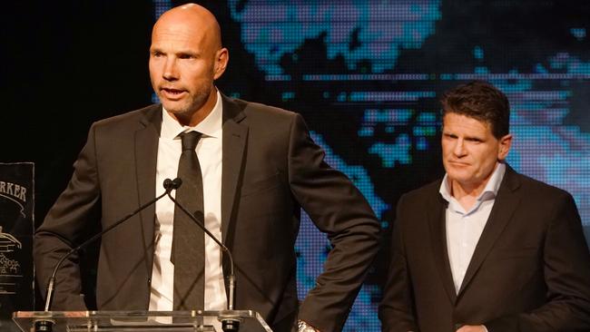 Former St. Kilda players Stewart Loewe (left) and Robert Harvey make their tributes to former St. Kilda Saints player Danny Frawley during the 2019 Trevor Barker Award presentation at Crown Palladium in Melbourne, Wednesday, September 11, 2019. (AAP Image/Michael Dodge) NO ARCHIVING