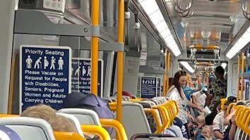 Gold Coast Titans fans leaving Robina station after a game wait on a train as delays occur due to track work.