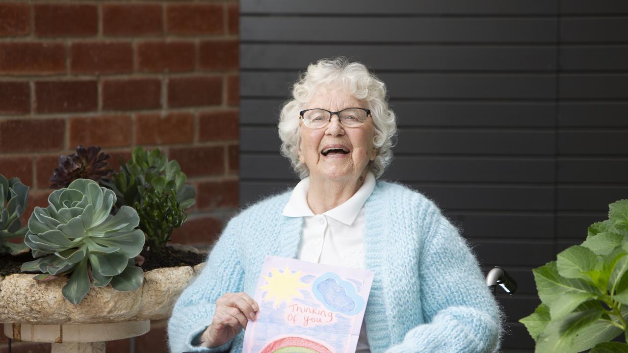 Bupa Aged Care Resident Maureen Martens, 89, holding a kindness card in the courtyard at her residence in Campbelltown, South Australia. Picture: Emma Brasier