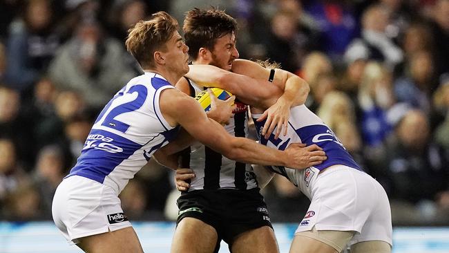 MELBOURNE, AUSTRALIA - JUNE 29: Tom Phillips of the Magpies is tackled by Mason Wood of the Kangaroos (L) and Jack Ziebell during the Round 15 AFL match between Collingwood v North Melbourne at Marvel Stadium on June 29, 2019 in Melbourne, Australia. (Photo by Michael Dodge/Getty Images)