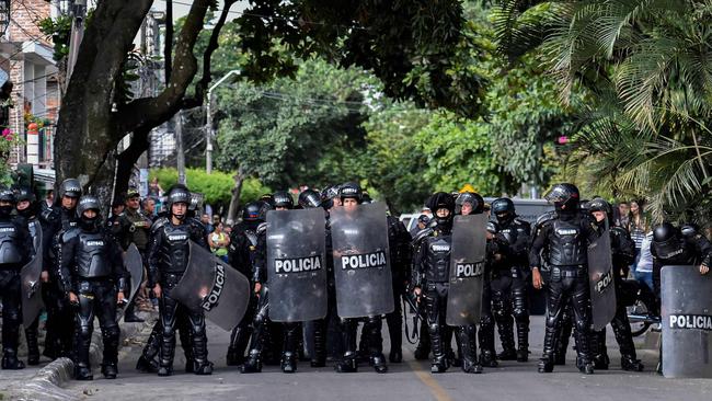 Riot police stand guard outside the community hall of the Aguablanca neighborhood, in Cali, Colombia, on December 6, 2019, before the arrival of Colombian President Ivan Duque to attend a national dialogue convened in response to protests against his government. (Photo by Luis ROBAYO / AFP)