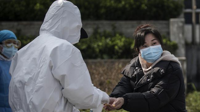 Doctors disinfect a discharged COVID-19 patient while she leaves Wuchang Fang Cang makeshift hospital, which is the latest temporary hospital being shut down, on March 10, 2020 in Wuhan, Hubei province, China. Picture: Getty Images