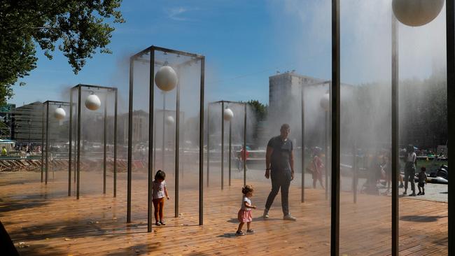 People walk in a steam fountain at the Bassin de la Villette on the opening day of the 19th edition of the ‘Paris Beaches’ event. Picture: AFP