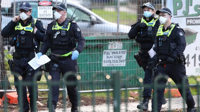 Police patrol outside towers on Racecourse Road in Flemington. Picture: David Crosling