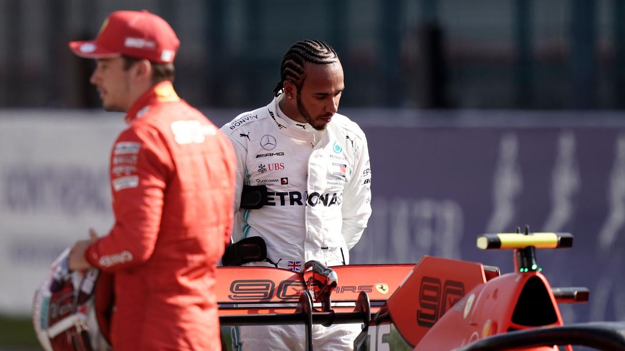 Lewis Hamilton (R) looks at the car of Charles Leclerc (L) after qualifying at Spa-Francorchamps.