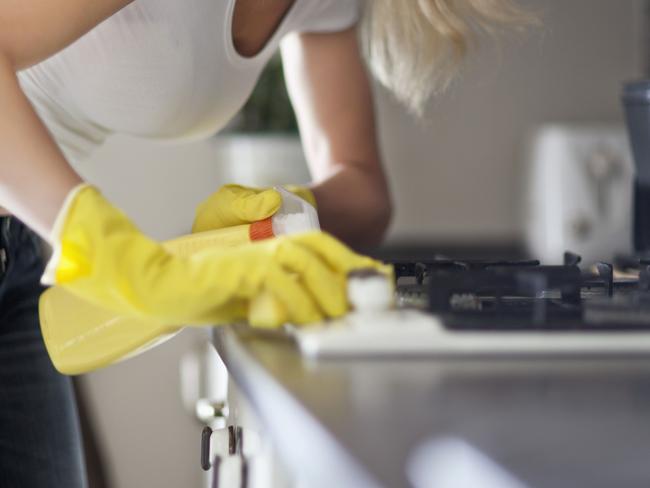 Young woman cleaning kitchen cabinets. Housework. Female. Generic image.