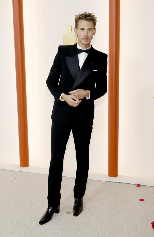 Elvis star Austin Butler wears a Saint Laurent tuxedo to the Oscars, slim cut with wide satin lapels. Picture: Getty Images