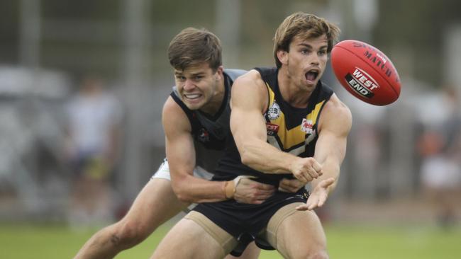 Brighton’s Dylan Lang is tackled by Adelaide University's Matt Langridge during the clash at Brighton Oval on Saturday. Picture: AAP/Dean Martin