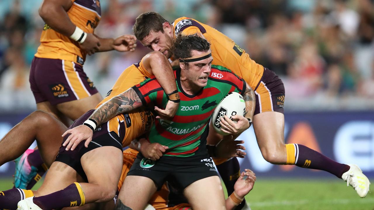 Ethan Lowe of the Rabbitohs is tackled by the Broncos 