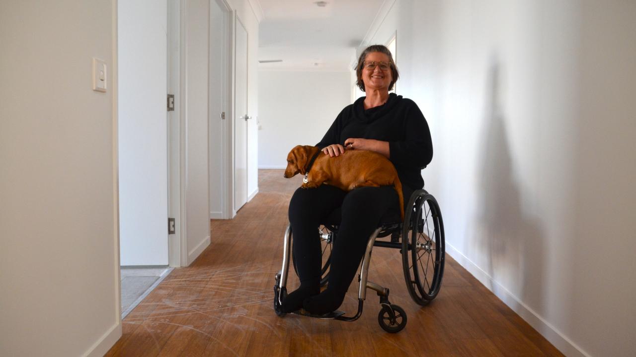 Asti Savage and her dog Jag show off an Elliot Springs home built to NDIS 'high physical support' spec. The home is brand-new and just come on the market.