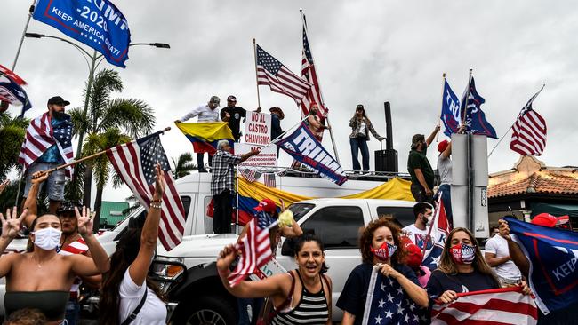 Supporters of US President Donald Trump hold signs and flags during a protest in Miami after Joe Biden was declared the winner of the 2020 presidential election.