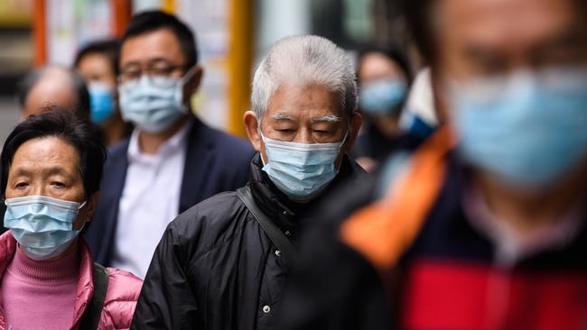 Pedestrians wear face masks in Hong Kong as a preventative measure following an outbreak of a new virus, believed to have begun in the Chinese city of Wuhan. Photo: Anthony Wallace, AFP.