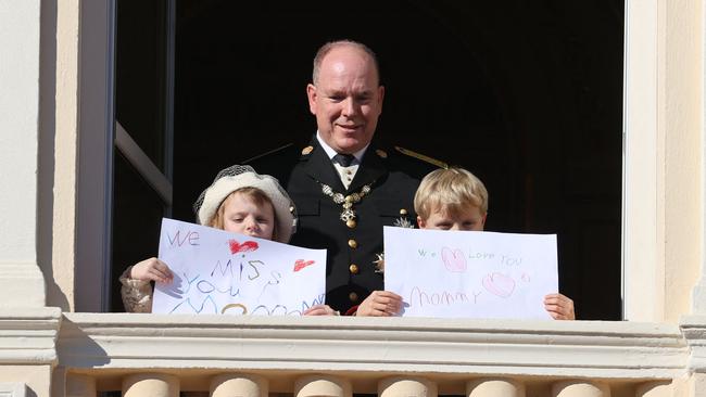 Princess Gabriella and Prince Jacques stand with their father, holding messages for Princess Charlene at the balcony of Monaco Palace during the celebrations marking Monaco’s National Day on November 19, 2021. Picture: Valery Hache/AFP