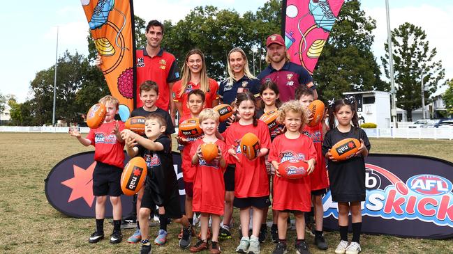 Auskickers pose with Ben King and Claudia Whitfort of the Suns and Daniel Rich and Natalie Grider of the Brisbane Lions. Picture: Chris Hyde/AFL Photos/Getty Images