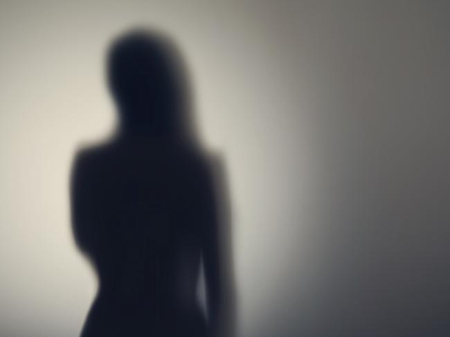 Silhouette of naked woman's body  behind glass door. Concept Picture: Istock