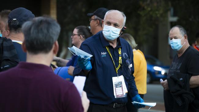 An official is seen handing out masks, which became mandatory in WA after the Premier announced a three-day lockdown Photo by Matt Jelonek/Getty Images.