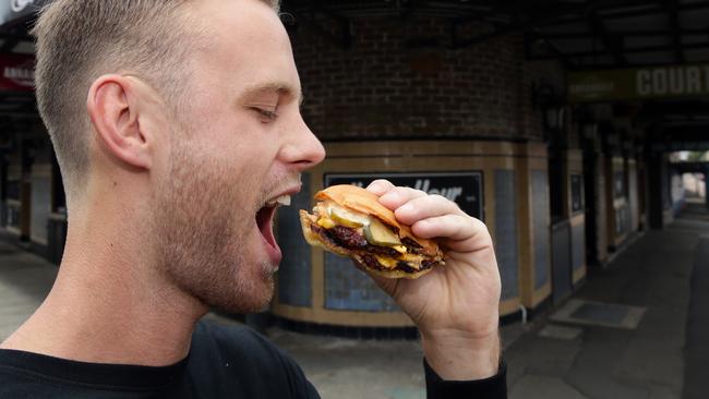 Grant Lawn with his Double cheese burger at The Annandale Hotel. Picture: Craig Wilson