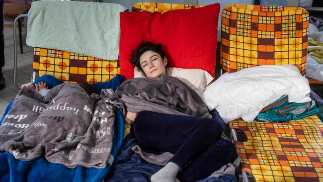 A Ukrainian refugee is seen resting in a temporary reception point organised in the main railway station in Przemysl, in eastern Poland. Picture: AFP