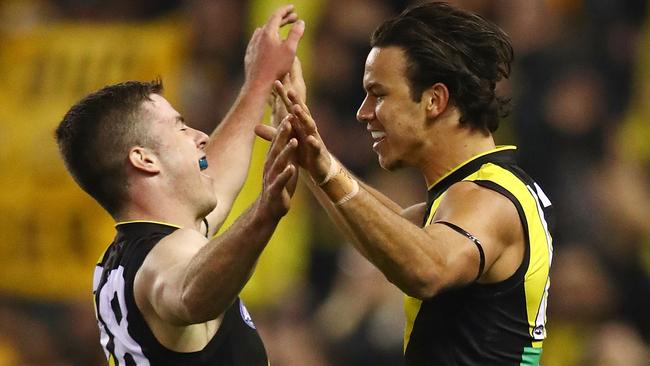 Daniel Rioli of the Tigers celebrates after kicking a goal with Jack Higgins.