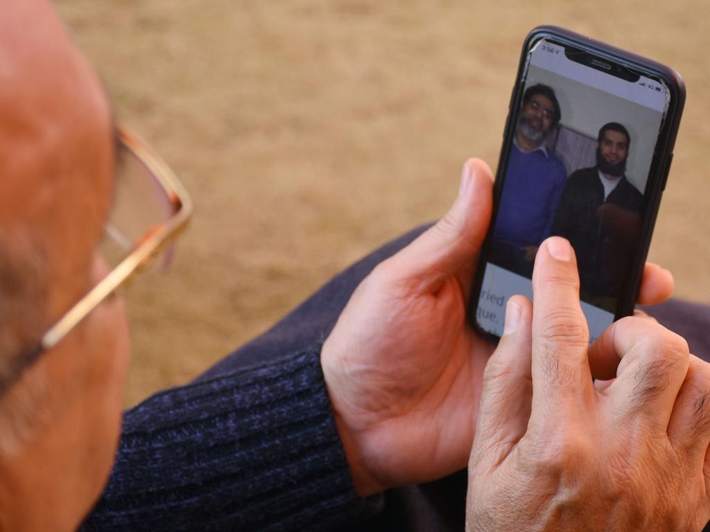 A relative looks at a picture on a mobile phone of Pakistani nationals Naeem Rashid and his son Talha Naeem, who were killed in the Christchurch attacks. Picture: Jameel Ahmed /AFP