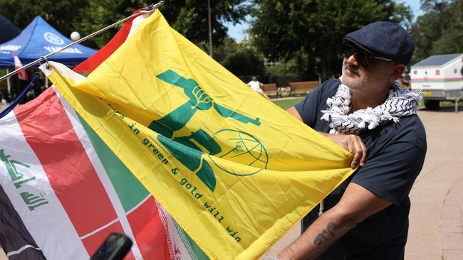 A pro-Palestine protester displays a flag mimicking the flag of terrorist group Hezbollah. Picture: NewsWire / Damian Shaw