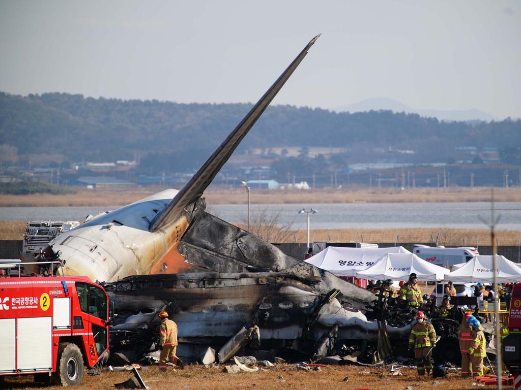 Rescue personnel work near the tail section of a Jeju Air Boeing 737-800 series aircraft after the plane crashed and burst into flames at Muan International Airport, 288 kilometres southwest of Seoul. Picture: AFP