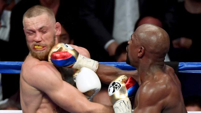 LAS VEGAS, NV — AUGUST 26: Floyd Mayweather Jr. (R) hits Conor McGregor with a right in the 10th round of their super welterweight boxing match at T-Mobile Arena on August 26, 2017 in Las Vegas, Nevada. Mayweather won by 10th-round TKO. Ethan Miller/Getty Images/AFP == FOR NEWSPAPERS, INTERNET, TELCOS &amp; TELEVISION USE ONLY ==