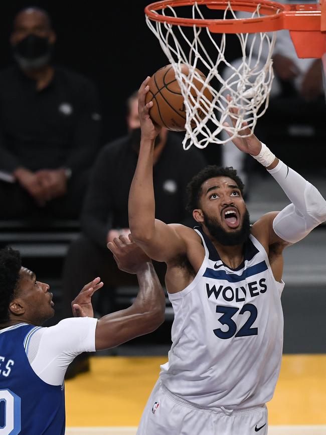 Karl-Anthony Towns reaching for the net. (Credit: Harry How/Getty Images)