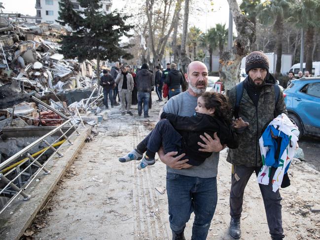 A man carries a child from a collapsed building in Hatay, Turkey. Picture: Getty Images