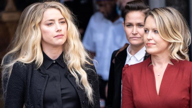 Bianca Butti, right, partner of US actress Amber Heard, left, listens as Heard makes a statement to members of the media outside the High Court. Picture: Niklas Hallen/AFP