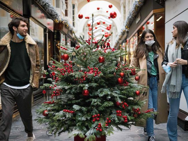 Pedestrians wearing face masks due to the COVID-19 pandemic, walk past Christmas-themed window displays inside Burlington Arcade in central London. Picture: AFP