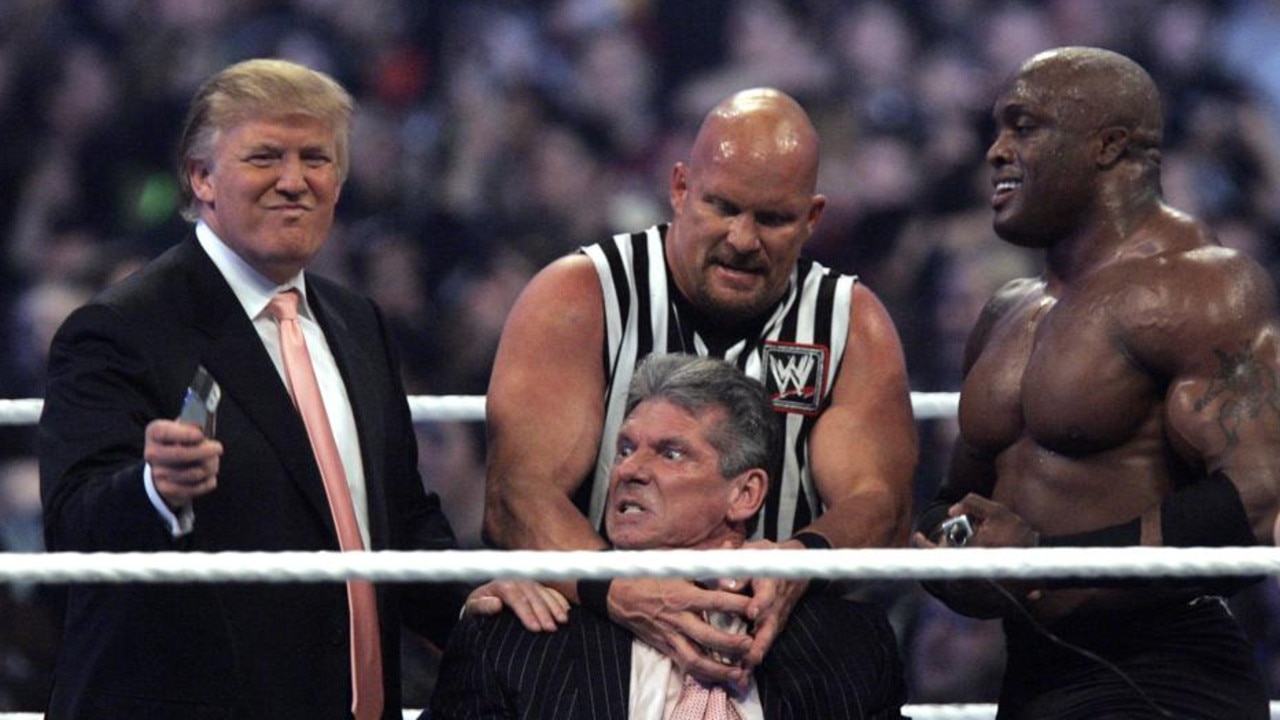 WWE Chairman Vince McMahon, centre, held by "Stone Cold" Steve Austin, prepares to have his hair cut off by Donald Trump, left, and Bobby Lashley, right.