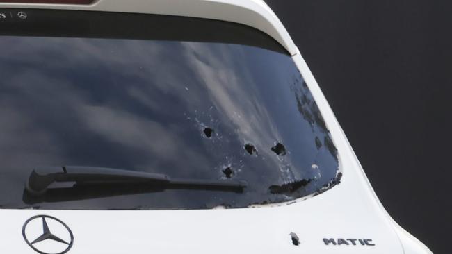 Bullet holes pepper the back and front of a white Mercedes. Picture: David Caird