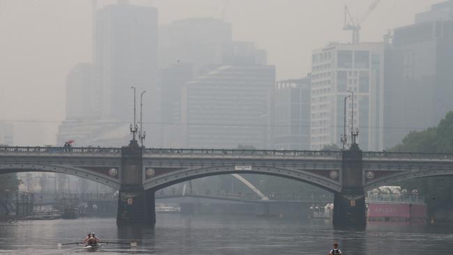 Bushfire smoke haze and light rain hang over Melbourne CBD on Monday. Picture: David Crosling