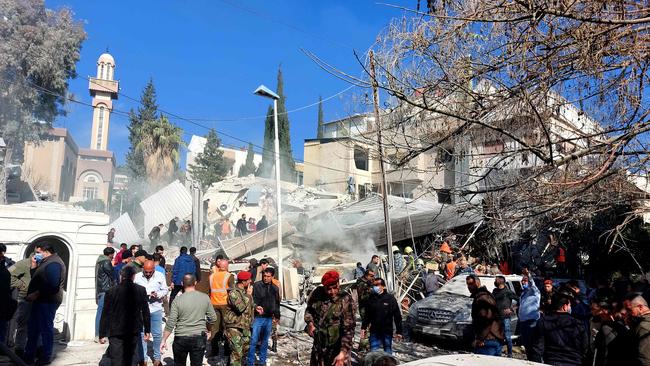 People and security forces gather in front of a building destroyed in a reported Israeli strike in Damascus, which killed five people in a building where ‘Iran-aligned leaders’ were meeting. Picture: AFP