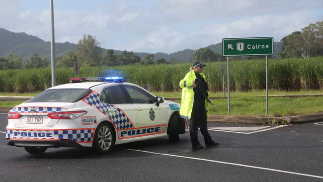 Police are locked in a standoff with an armed man on the Captain Cook Hwy who has refused to surrender himself to officers. A police officer blocks the Captain Cook Highway at the Yorkeys Knob roundabout. PICTURE: STEWART McLEAN