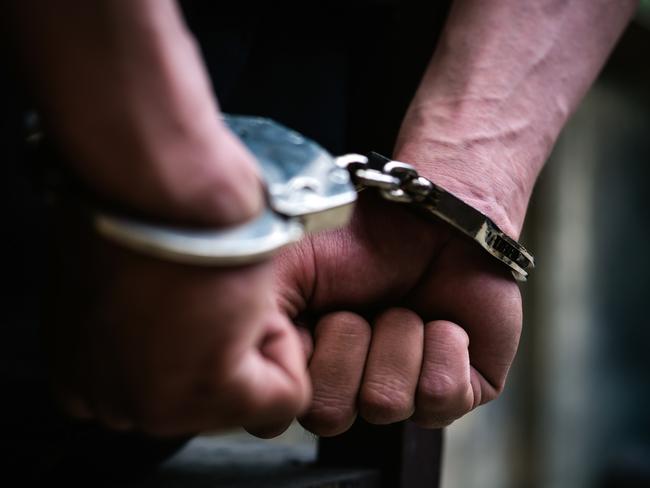 Man on the chair in Handcuffs. Rear view and Closeup ,Men criminal in handcuffs arrested for crimes. With hands in back,boy  prison shackle in the jail violence concept.