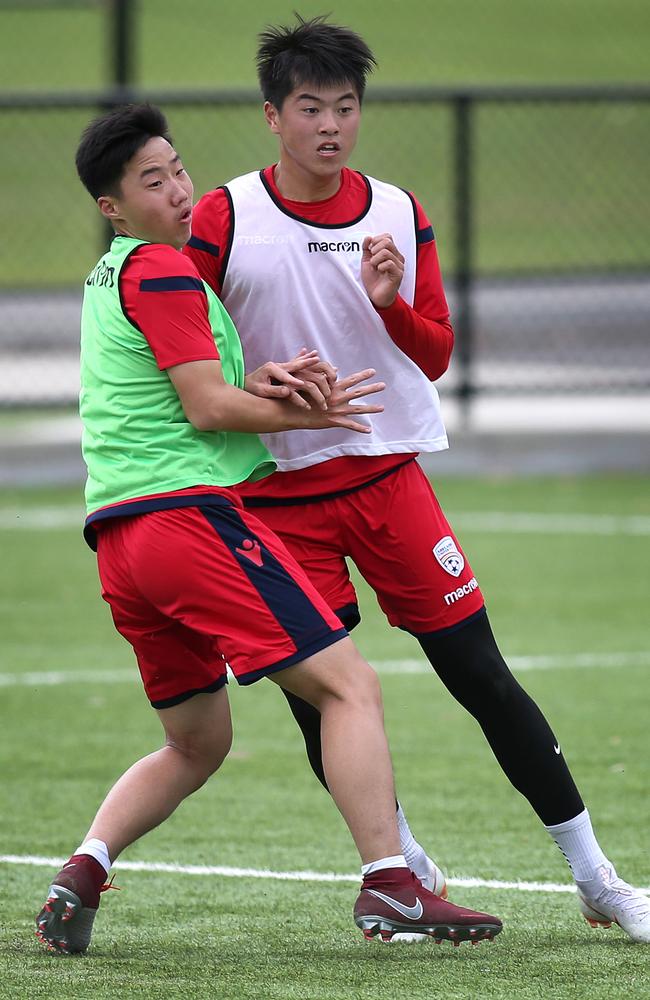 Striker Tang Chuang 22, right, battles Jiao Zi Yuan during and Adelaide United training session at the Parks Community Centre. Picture: AAP Image/Dean Martin