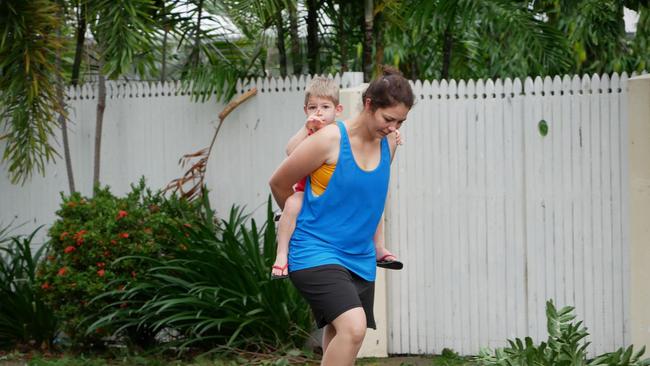 A mother and son survey damage to gardens at houses and the primary school on Potts Street, Belgian Gardens.