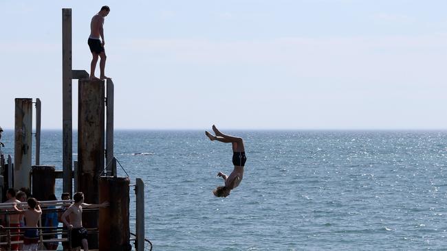 Jetty jumpers at Glenelg Beach during hot weather in 2015. Picture: Simon Cross