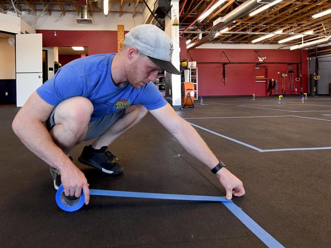 Owner Chad Cole marks out social distancing space at CrossFit Apollo gym in Las Vegas, Nevada. Expect to see similar arrangements when Australian gyms open their doors. Picture: Ethan Miller/Getty Images/AFP