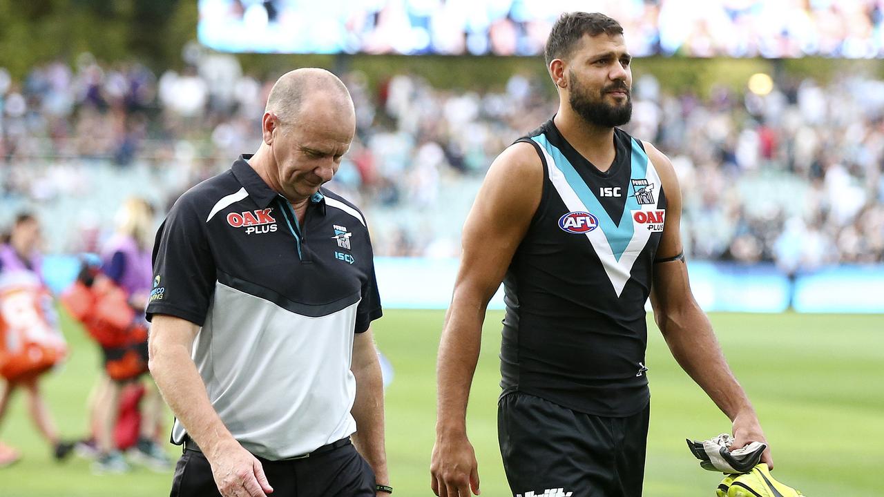 Ken Hinkley walks off the oval with the injured Paddy Ryder in Round 1.