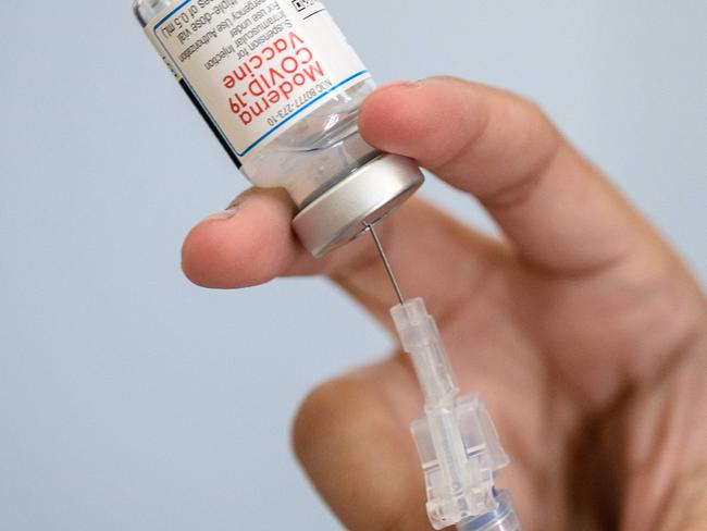 (FILES) In this file photo taken on April 16, 2021, a medical staff member prepares a syringe with Moderna Covid-19 vaccine at a pop up vaccine clinic at the Jewish Community Center in the Staten Island borough of New York City. - US vaccine maker Moderna expressed confidence on December 20, 2021, that its booster shot was effective against the Omicron variant, after the announcement of laboratory results it described as 