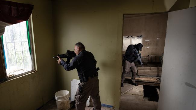 Police in the the house used to conceal the tunnel. Picture: Jason Edwards