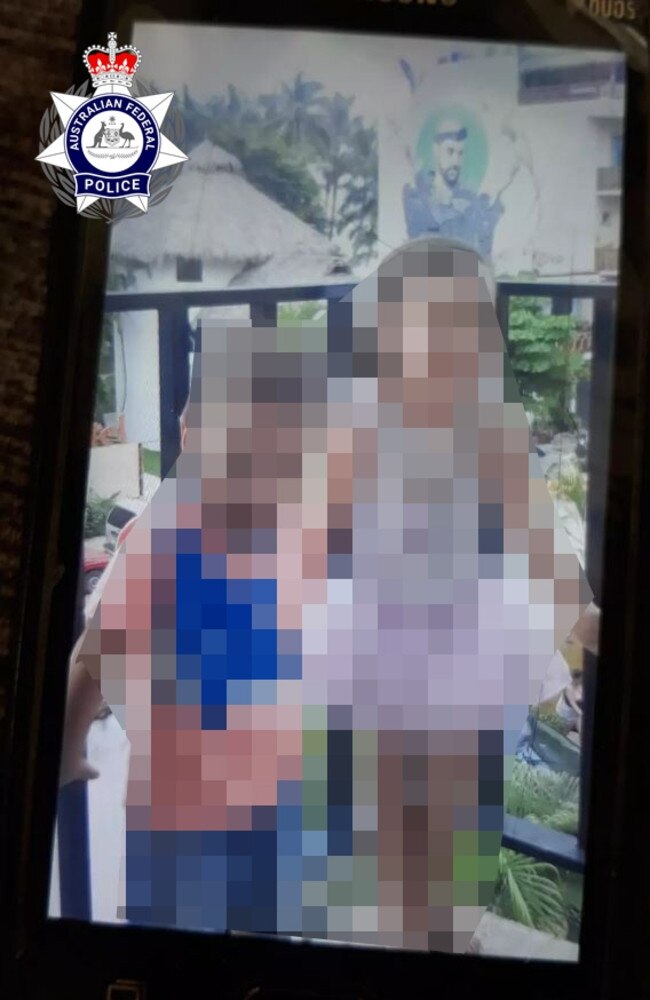 A photograph sent by Australian fugitive Anthony Phillip Sitar from his base in Mexico. The faces of two young children, believed to be Sitar's, have been blurred out. The mural in the background of the photograph, which was taken in Mexico, was significant. Police want to speak with anyone who knows the location of the villa units pictured.